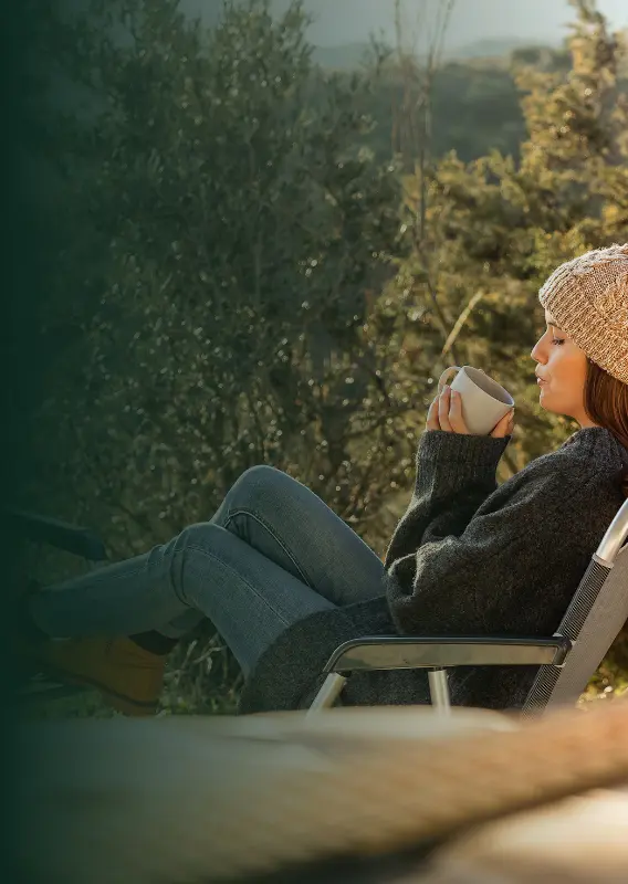 chica leyendo en el bosque miestras se toma un cafe mobile